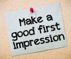 A sticky note pinned a to a board with the words "Make a good first impression" 