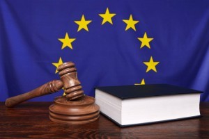 Gavel and legal law book in front of a flag of eh European Union.